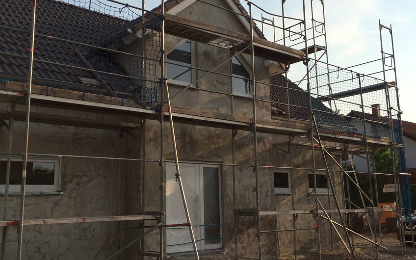 Verputzte Außenfassade auf der Eingangsseite des individuell geplanten Einfamilienhauses Aura von Kern-Haus in Wachenheim