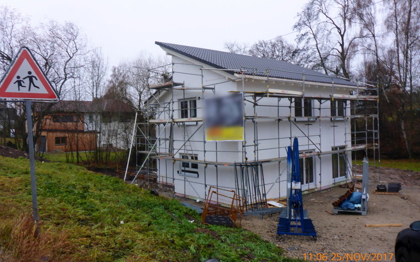 Ansicht Straßenseite mit Arbeitsgerüst und eingedecktem Dach.