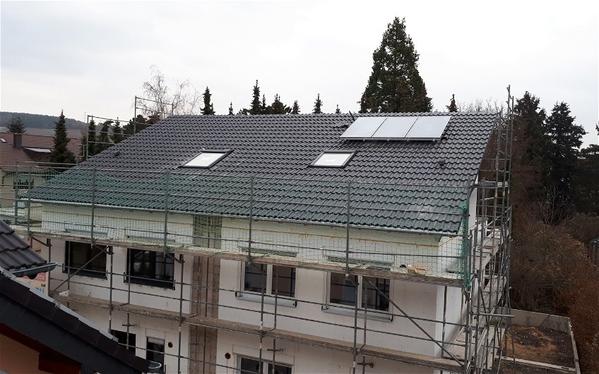 Das Dach wurde schnell fertig gestellt. Gut sichtbar die Solaranlage auf der einen Seite des Doppelhauses.