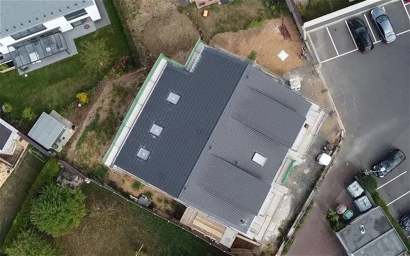 Mit der Drohne von oben fotografiert, das eingedeckte Dach den Mehrfamilienhauses.