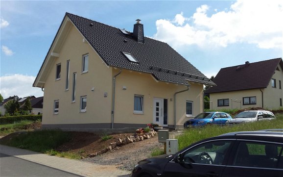 Haus mit Satteldach und gelbem Aussenputz