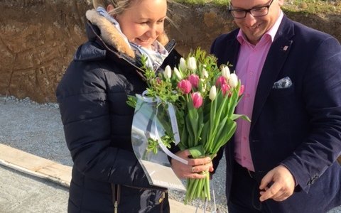 Unsere Bauherrin bekommt einen Blumengruß von Ronny Hartmann überreicht