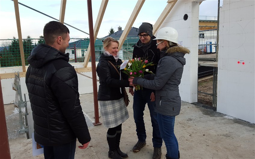 Unsere Projektleiterin ueberreicht der Bauherrin einen Blumengruss