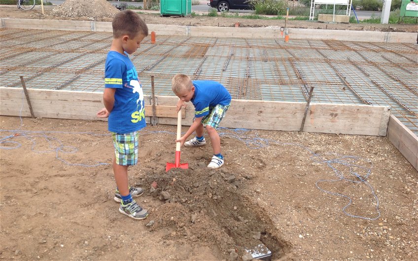 Kinder graben Loch für Grundsteinlegung