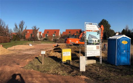 Beginn Tiefbauarbeiten auf Grundstück mit Bauschild und Bautoilette sowie Bagger für Kern-Haus in Halle-Braschwitz