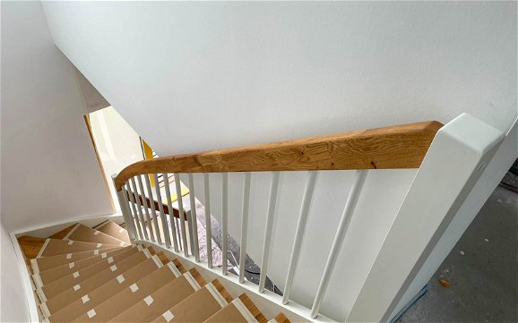 Vollholztreppe in weiß und Holzoptik im Flur des Kern-Haus Familienhaus in Halle Reideburg
