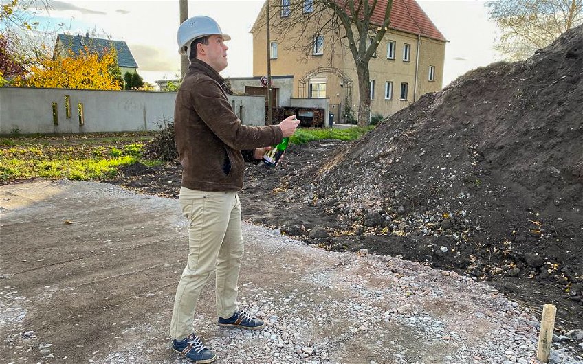 Bauherr lässt Sektkorken knallen zur Grundsteinlegung in Halle Reideburg