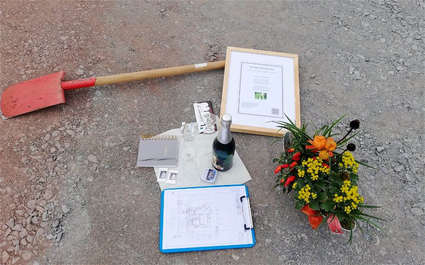 Spaten, Urkunde, Blumen und Sekt für Grundsteinlegung des Kern-Haus in Queis