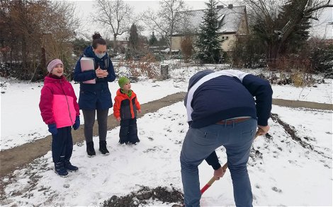Bauherr mit Familie beim Graben des Loches für Grundsteinkassette für Kern-Haus Jara in Halle Ammendorf