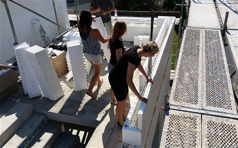 Kern-Haus-Mitarbeiter helfen beim Stecken der Wände des individuell geplanten Einfamilienhauses Vision Plus von Kern-Haus in Nußloch