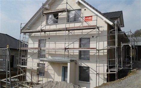 Straßenseite des frei geplanten Einfamilienhauses von Kern-Haus in Jagsthausen mit verputztem Mauerwerk