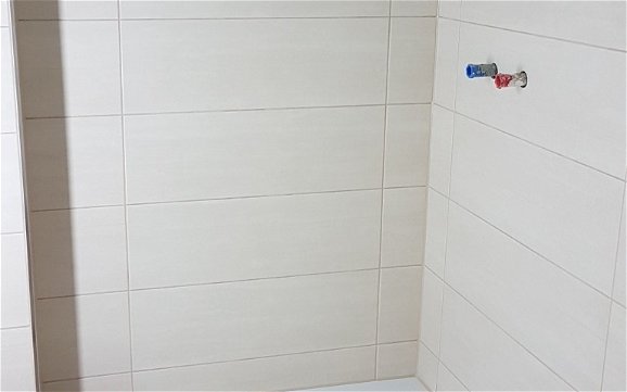 Gefliester Duschbereich im individuell geplanten Einfamilienhaus Loop Classic von Kern-Haus in Dielheim