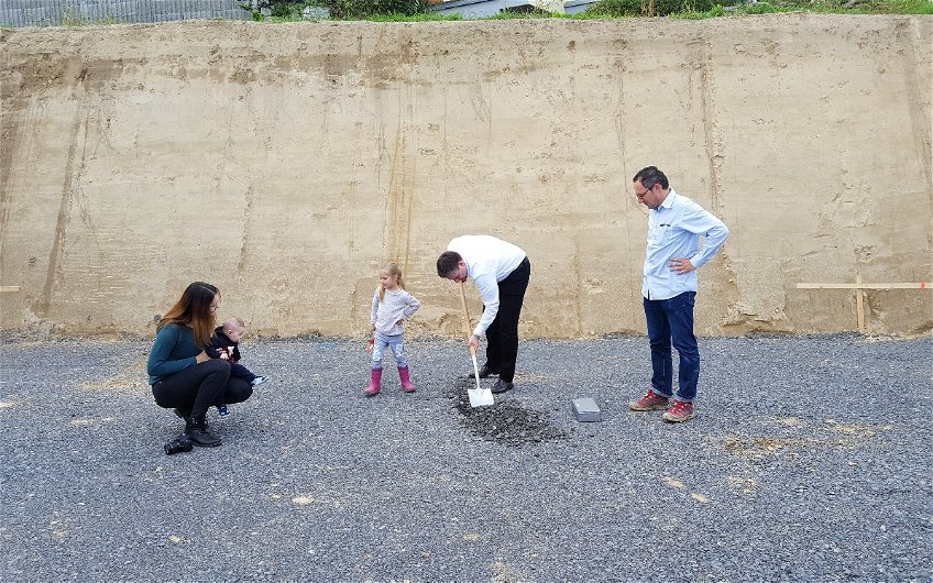 Bauherr gräbt das Loch bei der Grundsteinlegung für das frei geplante Einfamilienhaus von Kern-Haus in Angelbachtal