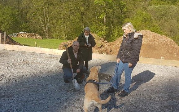 Baufamilie mit Hund bei der Grundsteinlegung für den frei geplanten Bungalow von Kern-Haus in Eberbach