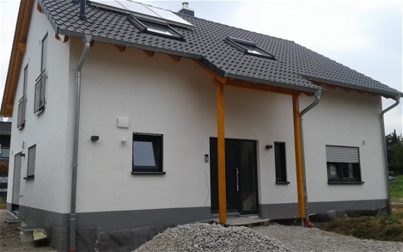 Eingangsseite des frei geplanten Einfamilienhauses von Kern-Haus in Bad Schönborn mit gestrichenem Sockel
