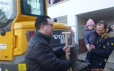 Dario Sauchelli übergibt Spaten bei der Grundsteinlegung für das frei geplante Doppelhaus von Kern-Haus in Mannheim-Feudenheim