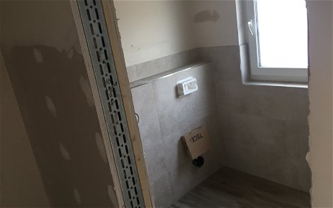 Fliesen im Gäste-WC der frei geplanten Doppelhaushälfte von Kern-Haus in Ketsch