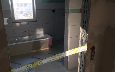 Verlegung der Fliesen im Badezimmer der individuell geplanten Doppelhaushälfte Twin L von Kern-Haus in Ketsch