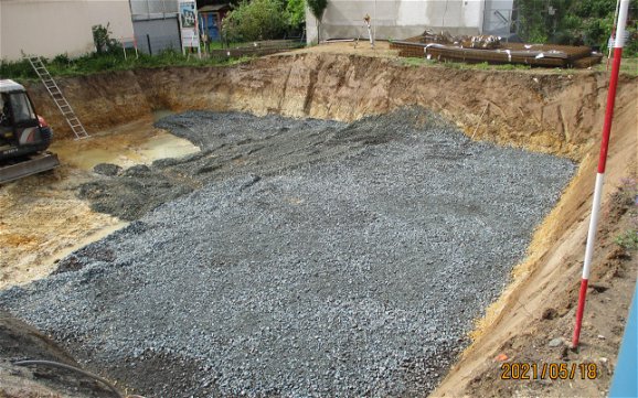 Die Baugrube wurde ausgeschachtet und nun wird der Untergrund für die Bodenplatte vorbereitet.