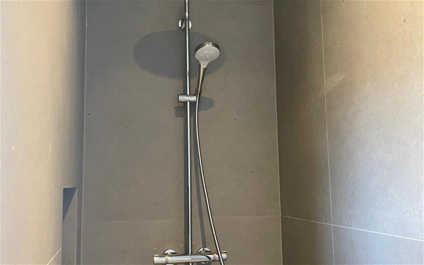 Die Dusche im Badezimmer ist an die Farbgestaltung optimal angepasst.