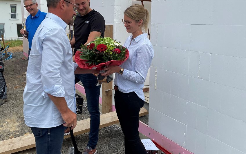 Mario Wilhelmi beglückwünschte die Bauherren und überreichte der Dame einen schönen Blumenstrauß.