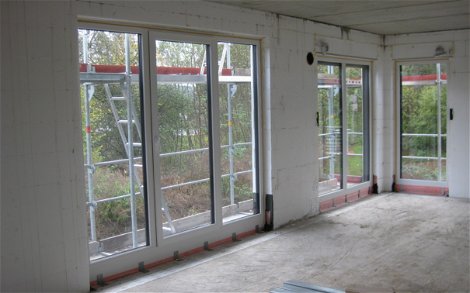 Der großzügige Wohn- und Essbereich wird durch zahlreiche Fenster mit viel Tageslicht versorgt.