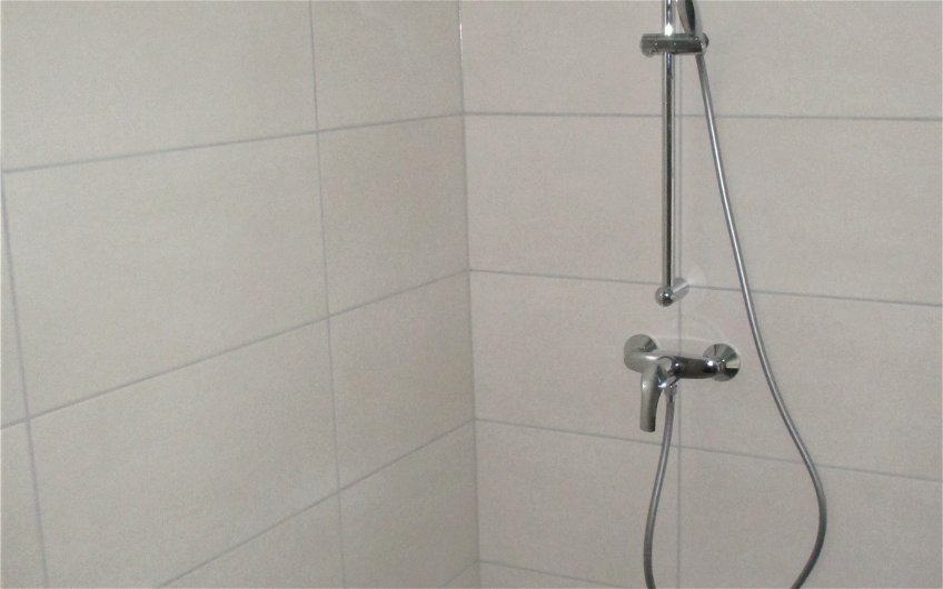 Die begehbare Dusche ist das komfortable Highlight im Badezimmer.