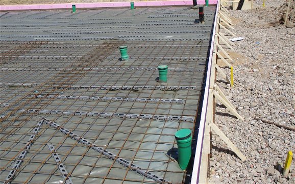 Durch die Schalung der Bodenplatte wird verhindert, dass Beton aus seiner Begrenzung der vorgegebenen Maße fließt.