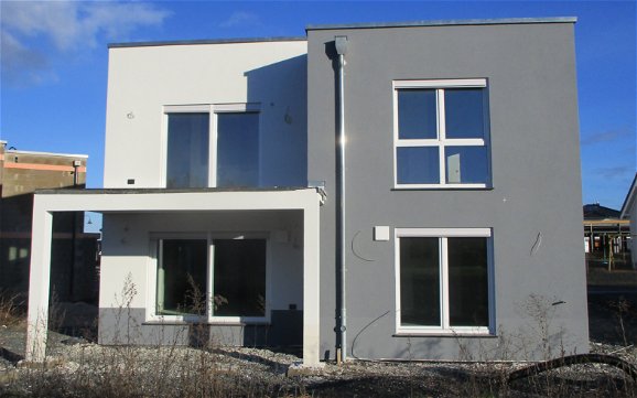 Das moderne Haus wurde zweifarbig gestaltet, so setzt sich der Kubus bildlich ab.