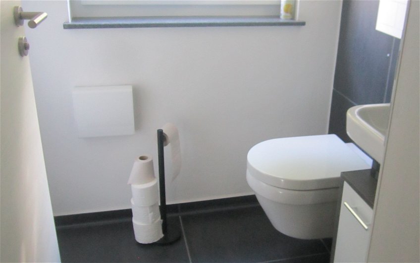 Die Sanitärobjekte, wie Toilette, Waschbecken und Spiegel wurden montiert.