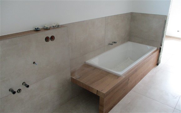 Die dekorative Ablagefläche der Badewanne kommt mit der Badewannenverkleidung gut zur Geltung.