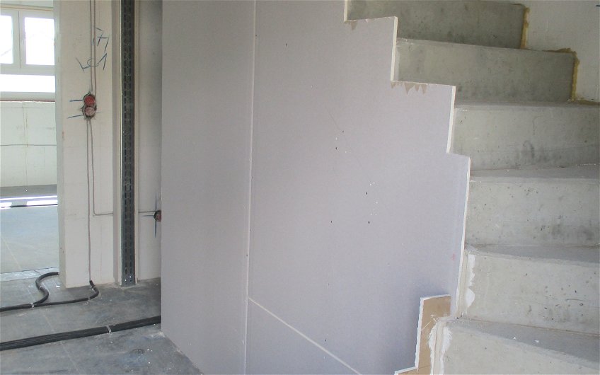 Nachdem die Metallständerwände unter der Treppe montiert wurden, konnte diese mit Gipskartonplatten beplankt werden. 