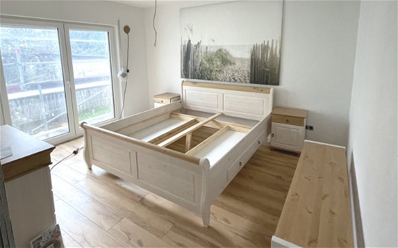 Die Möbel im Landhausstil im Schlafzimmer konnten bereits aufgebaut werden.