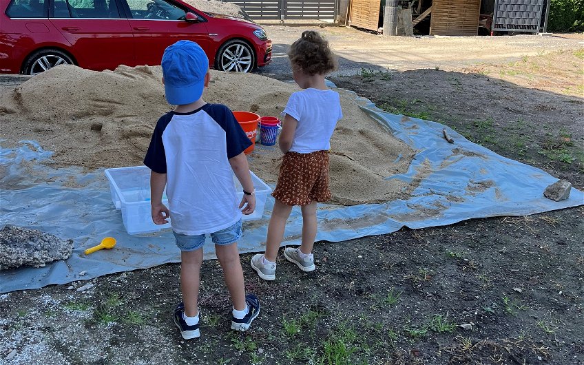 Ein Spieleparadies für die anwesenden Kinder ist der große Sandhaufen.
