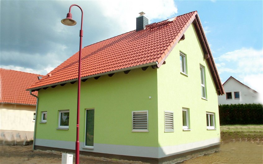 Kern-Haus Familienhaus mit grünem Außenputz und rotem Dach