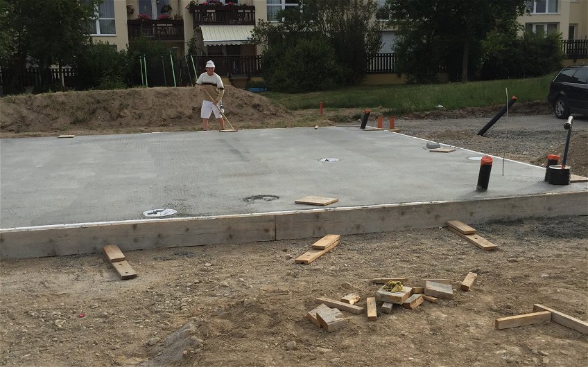 Fertigstellung Bodenplatte mit Bauarbeiter