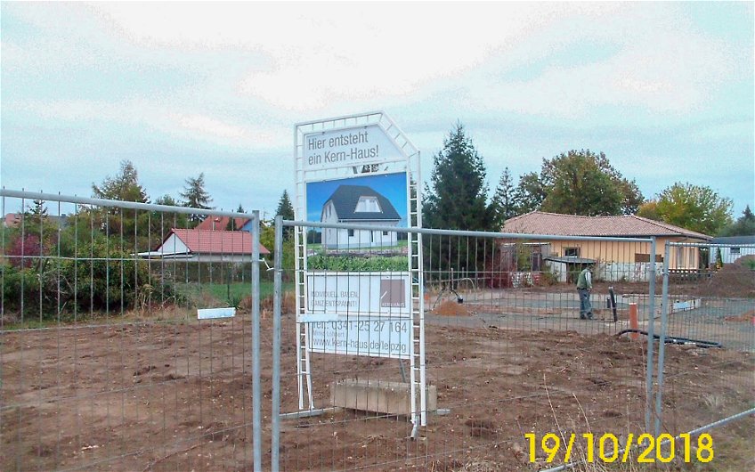 Vorbereitungen der Bodenplatte und Bauschild auf Grundstück für Kern-Haus in Grimma