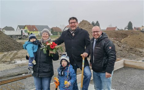 Bauherren mit Verkaufsberater bei Grundsteinlegung für Kern-Haus in Großpösna