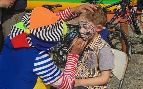 Kind und Clown beim Gesicht schminken auf Kern-Haus Rohbaufest in Großpösna