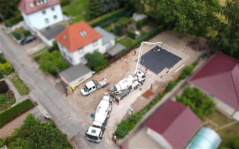 Betonmischer beim Verfüllen der Bodenplatte für Kern-Haus in Zweinaundorf aus Vogelperspektive