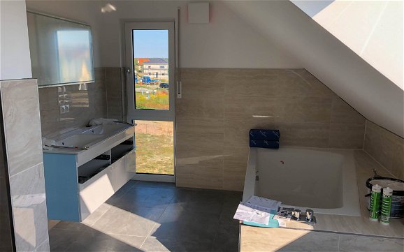 Bad gefliest mit Badmöbeln und Badewanne in Kern-Haus in Machern
