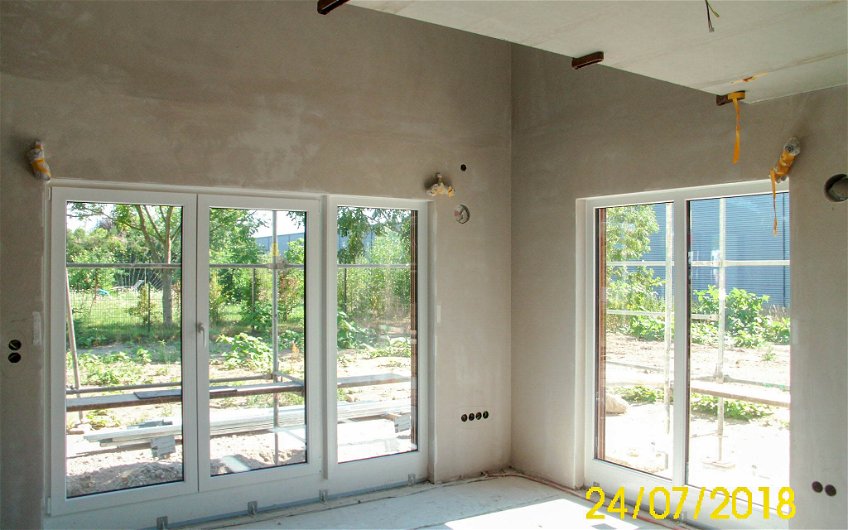Wohnbereich mit großen Fenstern und Innenputzarbeiten in Kern-Haus Rohbau in Taucha