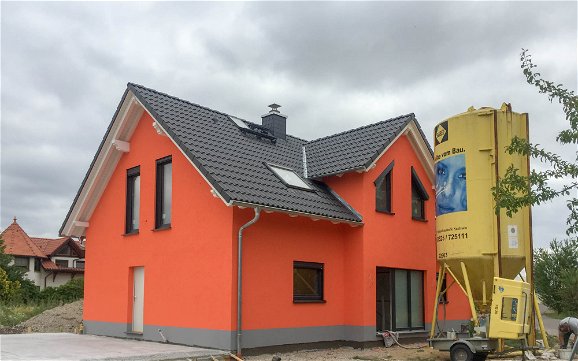 Kern-Haus Rohbau mit orangem Außenputz in Markranstädt