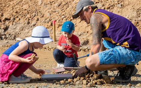 Bauherr mit Kindern beim Vergraben der Grundsteinkassette für Kern-Haus in Großsteinberg