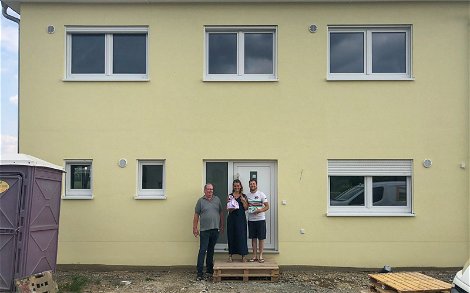 Bauherren mit Kern-Haus Bauleiter Frank Weigend vor Stadtvilla mit gelbem Putz in Pegau