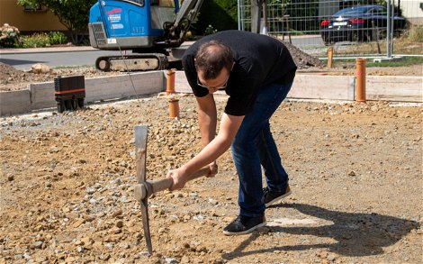 Bauherr mit Spitzhacke für Grundsteinlegung eines Kern-Haus in Eilenburg