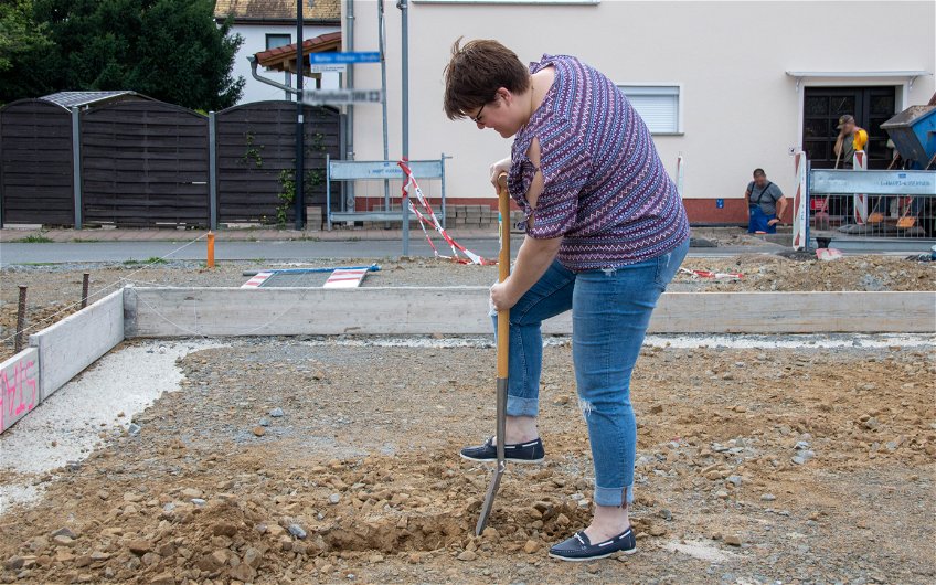 Bauherrin mit Spaten bei Grundsteinlegung für Kern-Haus in Leipzig