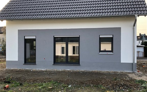 Terrassenseite des Kern-Haus Luna mit grauem Außenputz in Eilenburg
