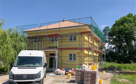 Kern-Haus Stadtvilla mit gelbem Außenputz und rotem Dach und Gerüst in Erdmannshain