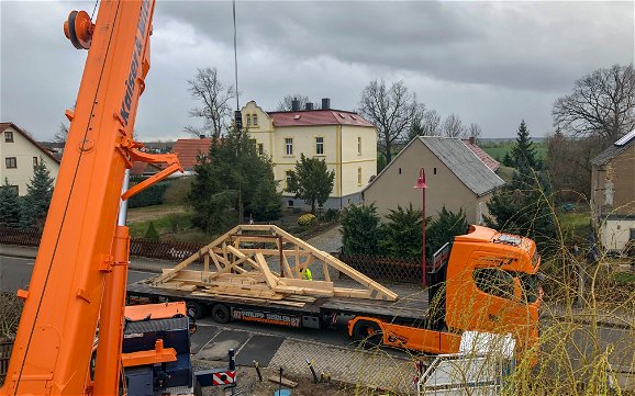 Anlieferung des Dachstuhls mit LKW und Kran für Kern-Haus Stadtvilla in Erdmannshain